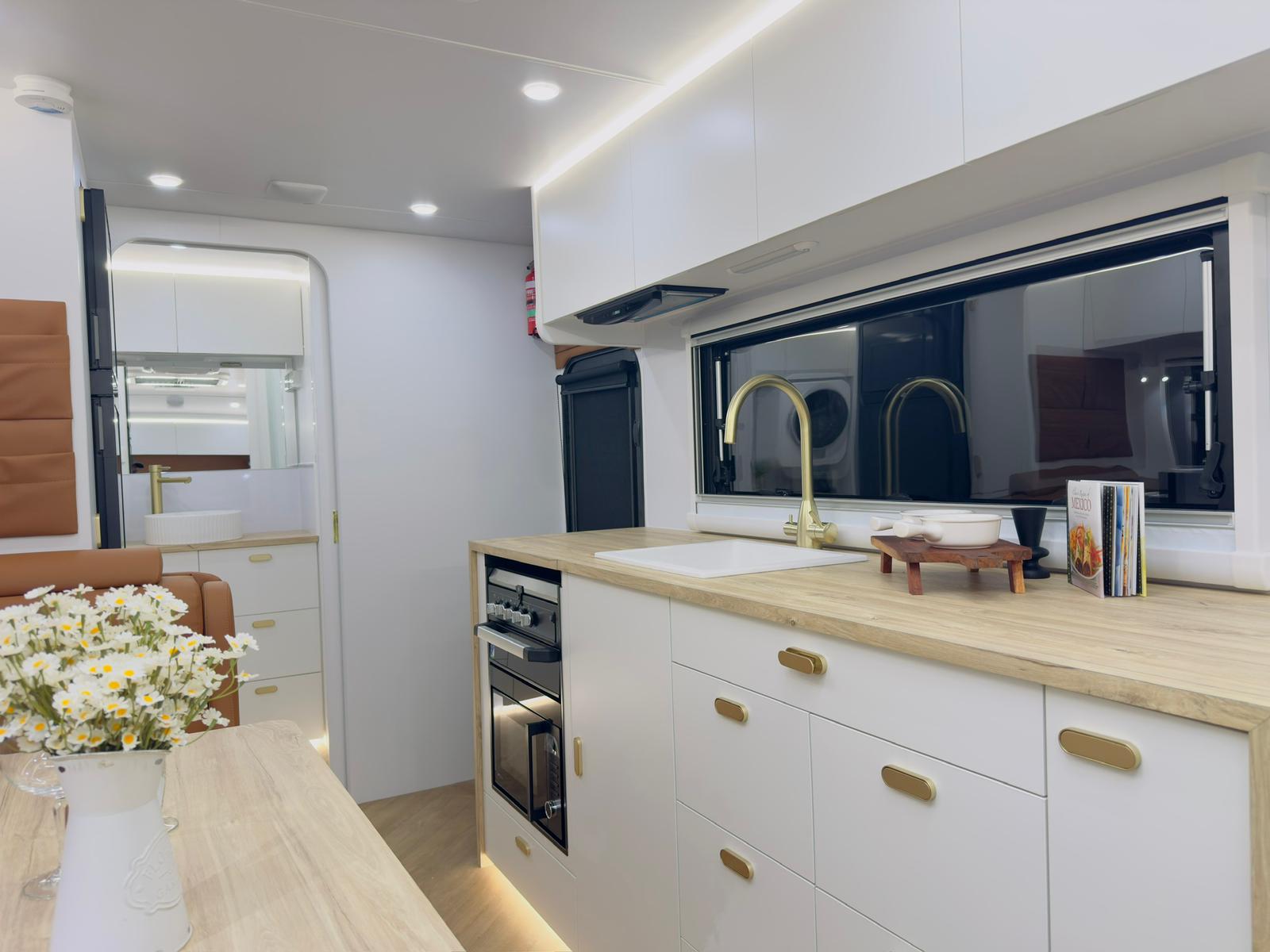 Custom caravan kitchen with timber bench and brass hardware